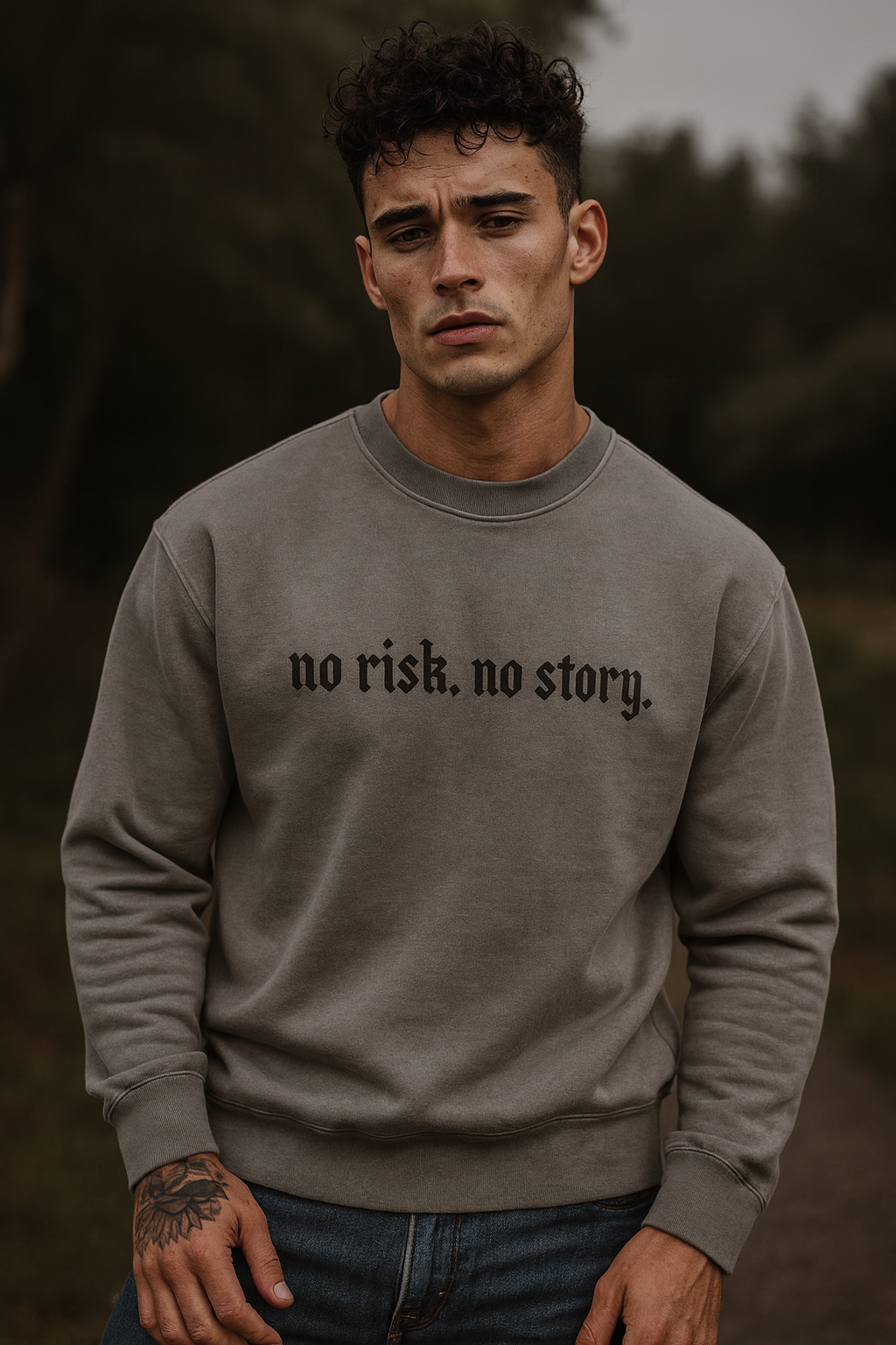 Man wearing a gray Iron & Velvet 'no risk, no story' crewneck sweatshirt